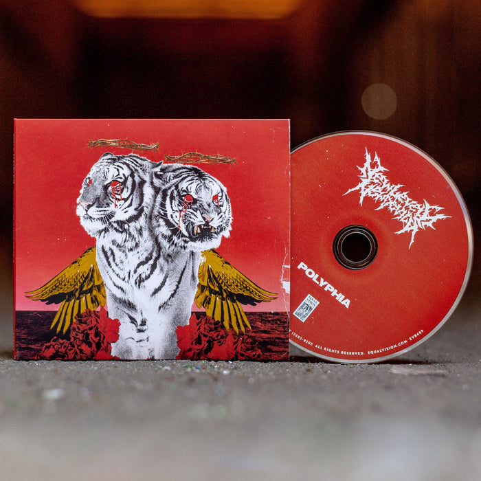 Square CD with two white tigers in the center. The tigers have yellow wings and red dripping from their eyes. There is a red disc peeking out of the cover, that says NEW LEVELS NEW DEVILS on top, and POLYPHIA on bottom. Both are sitting on a concrete surface.