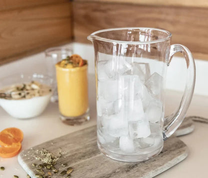 Medium Ascutney pitcher by Simon Pearce made of clear glass, shown in a lifestyle setting with a sleek, elegant design.