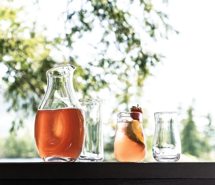 Simon Pearce Cloud Carafe with elegant glass design on a wooden table, showcasing its sleek, modern decanter style.