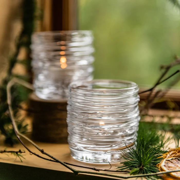 Pair of Simon Pearce Echo Lake tealight holders featuring clear glass with textured, reflective surfaces for elegant home decor.