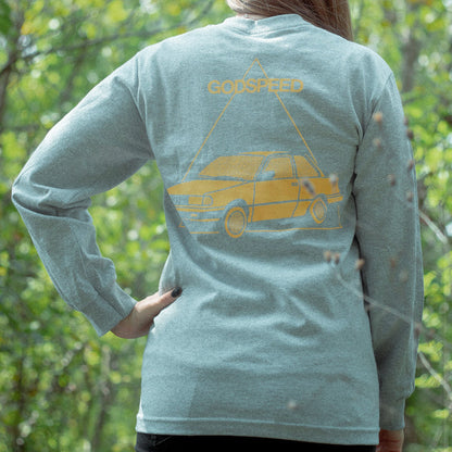 Grey long sleeve shirt with YNG CLTR in orange on the chest. On the back there is a ca drawn in orange with a triangle around it. Above that, there is text that says GODSPEED, also printed in orange. An individual is modeling the shirt and standing in front of greenery.