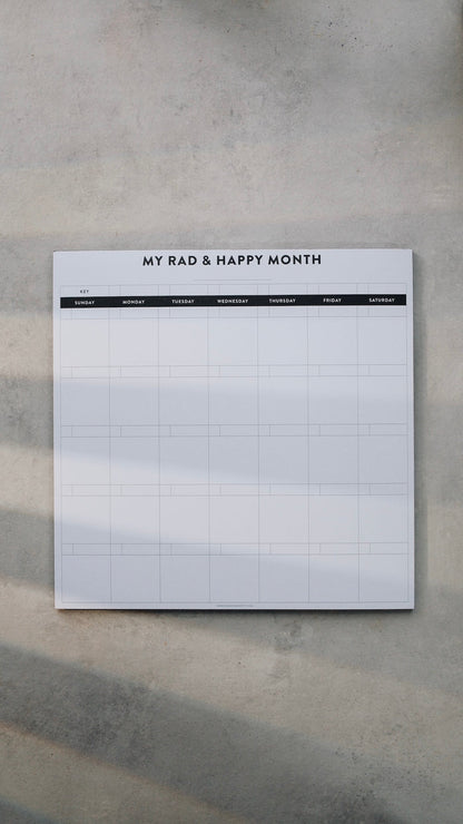 Monthly notepad with grid layout on a gray surface