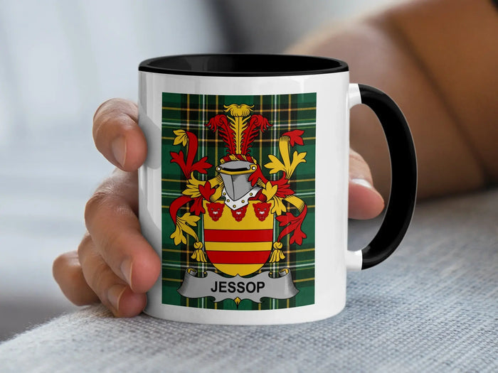 White mug with black rim displaying the Jessop family crest on a tartan background.