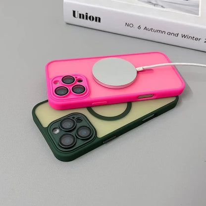 Two iPhones in colorful cases with a charging pad.