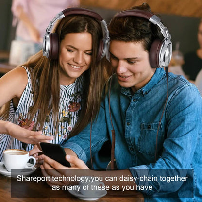 Two people wearing headphones and looking at a smartphone together.