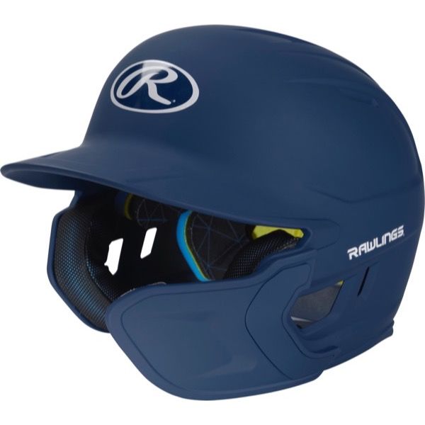 The Rawlings Mach Matte Batting Helmet with EXT Flap (MACHEXT) is a navy blue helmet featuring a protective face guard, black interior padding, and white Rawlings logos on the front and side.