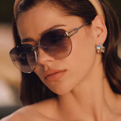 lifestyle - female sitting at a resturant wearing diff eyewear featuring the trista aviator sunglasses with a gold frame and slate blue gradient flash lenses angled view
